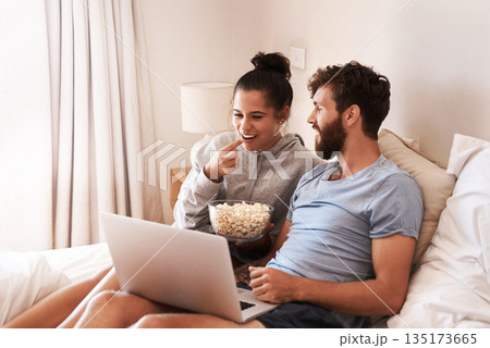 Laptop, watching movie and popcorn with couple in bed for streaming, relax or internet. Subscription, happy and love with man and woman eating at home for social media, funny and free time on weekend Laptop, watching movie and popcorn with couple in bed for streaming, relax or internet. Subscription, happy and love with man and woman eating at home for social media, funny and free time on weekend 135173665