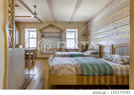 Rustic studio apartment interior with twin beds and wooden decor Rustic studio apartment interior with twin beds and wooden decor 135173701