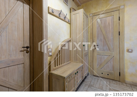 Rustic hallway interior with handcrafted wooden doors and painted furniture Rustic hallway interior with handcrafted wooden doors and painted furniture 135173702