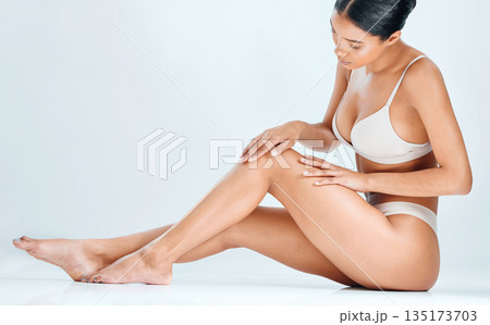 Woman, smooth skin and legs epilation of wellness, cosmetic wax and skincare treatment in studio. White background, happy female model and natural beauty with body care and leg shave in underwear 135173703