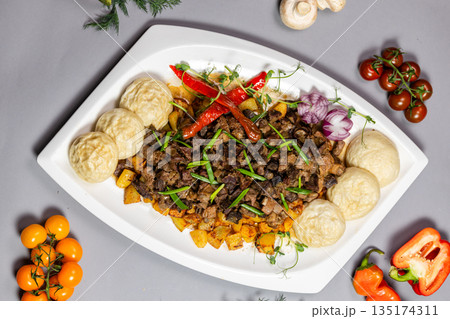 Top view of a traditional Kazakh meat dish, kuirdak, on a gray background 135174311