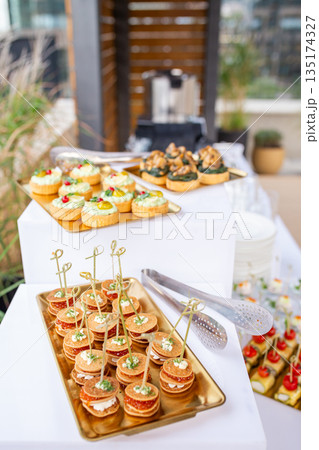 Top view of buffet table with canapes and mini tarts  135174327