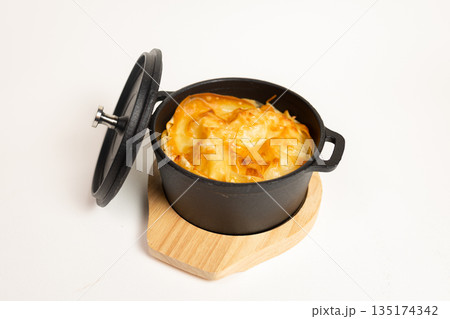 Close-up of baked dish in cast iron skillet - appetizing meal on white background 135174342