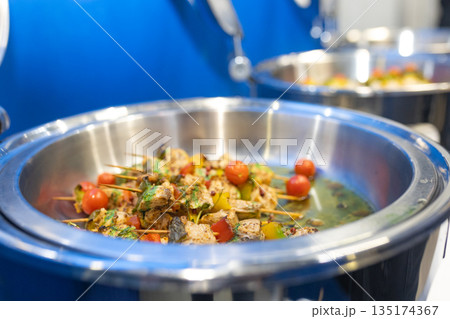 Close-up of chicken skewers with vegetables in metal bowl, details of texture and presentation 135174367