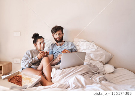 Hungry couple, pizza and movie on laptop in bed with junk food and streaming series. Eating, computer video and meal in a bedroom at home with man and woman with bonding, online watching and mockup 135174399
