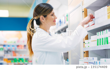 Pharmacy, product shelf and happy woman, pharmacist or chemist search for pills, supplements or pharmaceutical. Hospital retail dispensary, medicine and medical person fixing box package display 135174409