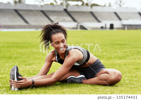 Happy woman, fitness and stretching body on grass for running, exercise or workout at the stadium. Active female person or athlete in warm up leg stretch for sports training or cardio run on a field Happy woman, fitness and stretching body on grass for running, exercise or workout at the stadium. Active female person or athlete in warm up leg stretch for sports training or cardio run on a field 135174431