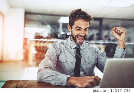 Business man, fist and celebration with laptop, winning or promotion at startup with excited face. Young businessman, winner and celebrate with computer, bonus or profit on investment on stock market 135174725