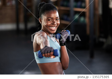 Portrait, dumbbell or happy black woman boxing in training, exercise or workout for a strong punch or power. Smile, face or African girl boxer with dumbbells, weights or exercising in fitness gym 135175305