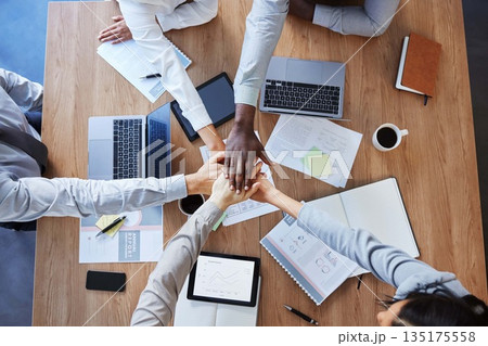 Hands in stack, teamwork or top view of business people in collaboration for mission goals in company. Partnership, diversity or employees in meeting with strategy, motivation or support in office Hands in stack, teamwork or top view of business people in collaboration for mission goals in company. Partnership, diversity or employees in meeting with strategy, motivation or support in office 135175558