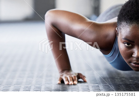 Portrait, focus and push ups with a black woman on the floor of a gym for exercise or fitness training. Face, half and mockup with a young female athlete doing a sports workout for strong muscles 135175581
