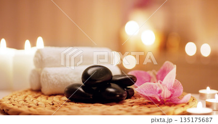 Candles, towels and hot stones at a spa for a massage, healing or luxury treatment therapy. Health, aromatherapy and wellness body care products for a calm, zen or peace atmosphere at a natural salon Candles, towels and hot stones at a spa for a massage, healing or luxury treatment therapy. Health, aromatherapy and wellness body care products for a calm, zen or peace atmosphere at a natural salon 135175687