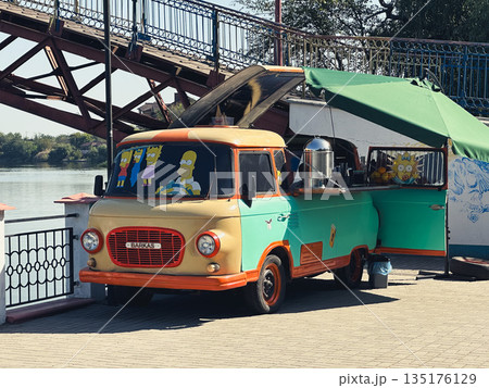 Vintage food truck by a river under a bridge. Vintage food truck by a river under a bridge. 135176129