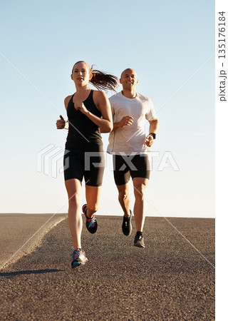 Morning, marathon and coach training woman as workout, run or morning exercise for health and wellness together. Sport, fitness and man runner running with athlete in a city for sports or energy Morning, marathon and coach training woman as workout, run or morning exercise for health and wellness together. Sport, fitness and man runner running with athlete in a city for sports or energy 135176184