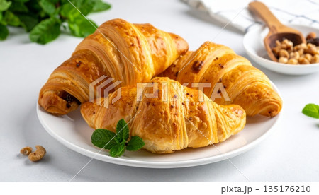 Deliciously fresh croissants on a white plate. Deliciously fresh croissants on a white plate. 135176210