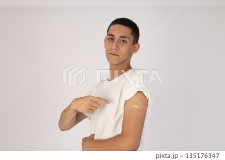 Young man in white t-shirt pointing at arm 135176347