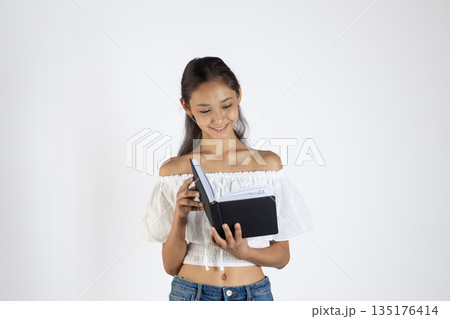 Girl in white shirt holding notebook 135176414