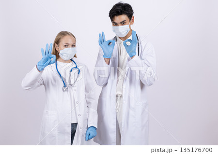 Two doctors in white coats wearing medical masks 135176700