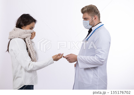 Nurse giving a bottle of pills to a patient 135176702