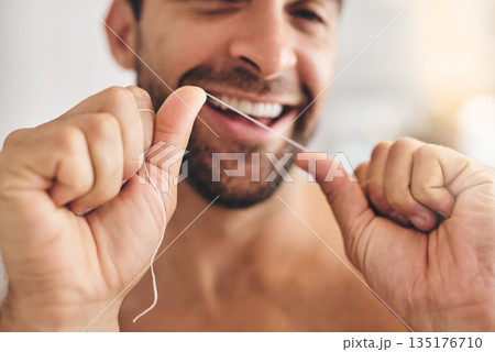 Hands, face and man flossing teeth at home for dental health, plaque and gingivitis on gums. Closeup of guy, oral thread and cleaning mouth for fresh breath, tooth hygiene and habit to care for smile Hands, face and man flossing teeth at home for dental health, plaque and gingivitis on gums. Closeup of guy, oral thread and cleaning mouth for fresh breath, tooth hygiene and habit to care for smile 135176710