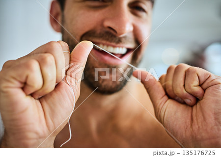 Hands, face and man floss teeth for smile, dental health and care for gum gingivitis at home. Closeup of happy guy, oral thread and cleaning mouth for fresh breath, tooth hygiene and healthy habit Hands, face and man floss teeth for smile, dental health and care for gum gingivitis at home. Closeup of happy guy, oral thread and cleaning mouth for fresh breath, tooth hygiene and healthy habit 135176725