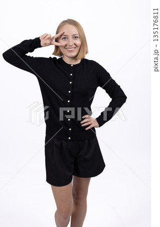 Woman in black clothes showing a superhero pose Woman in black clothes showing a superhero pose 135176811