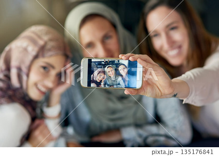Muslim women, friends and selfie with phone, smile and happiness for post on blog, app or social network. Happy islamic woman, group and smartphone for photography, profile picture and memory on web 135176841