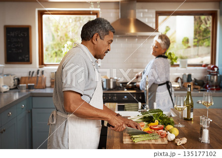 Cooking, vegetables and old man with woman in kitchen, happiness and healthy bonding time in home. Marriage, love and food, senior couple with meal prep for vegetable dinner with retirement wellness. 135177102
