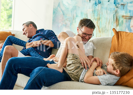 Gay parents, family and tickling in living room with dads and kids together with laugh. Parent love, bonding and care with father, papa and children in a home with a smile or fun lgbt people in house 135177230