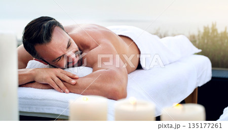 Man, spa and relax on massage table outdoor at holiday resort, vacation and peace at hotel. Mature male person resting on beauty salon bed for body cosmetics, luxury service and calm muscle therapy 135177261