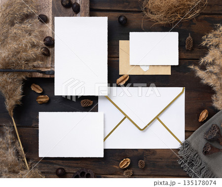 Cards and envelopes boho mockup on dark wood near natural decor and pampas grass top view Cards and envelopes boho mockup on dark wood near natural decor and pampas grass top view 135178074