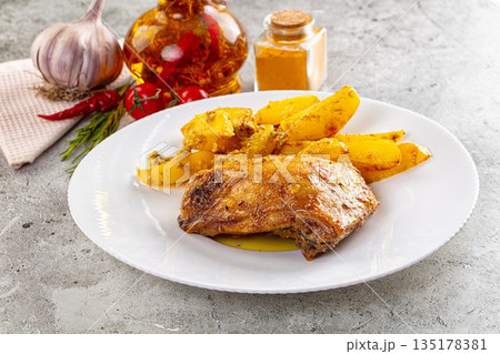 Baked chicken thighs with potatoes 135178381