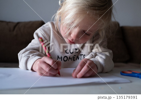 Preschool child doing homework and practicing writing skills, early education concept. Preschool child doing homework and practicing writing skills, early education concept. 135179391