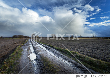 Dynamic clouds over dirt roads and rural fields Dynamic clouds over dirt roads and rural fields 135179438