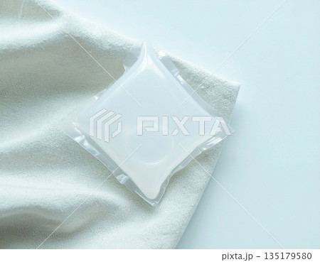 Fabric softener. Soluble laundry detergent capsule on a neutral linen cloth with empty space for text. Fabric softener. Soluble laundry detergent capsule on a neutral linen cloth with empty space for text. 135179580