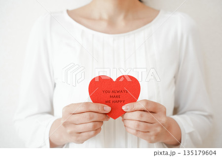 ハートのメッセージカードを持つ女性 135179604