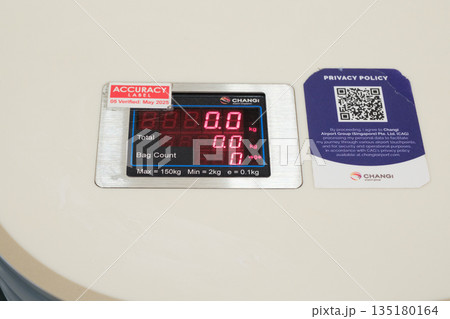 Changi Airport Singapore weight measurement scale showing zero readings and information notice board 135180164