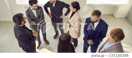 Group of positive business people in office having relaxed conversation over new project. Group of positive business people in office having relaxed conversation over new project. 135180306