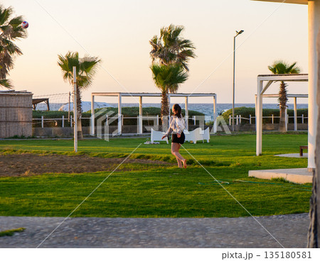 Family enjoys a sunny picnic in the park with games and laughter during a vibrant spring afternoon 135180581