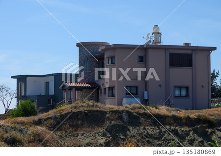 Modern hillside home with stone accents and serene surroundings in bright afternoon sunlight Modern hillside home with stone accents and serene surroundings in bright afternoon sunlight 135180869