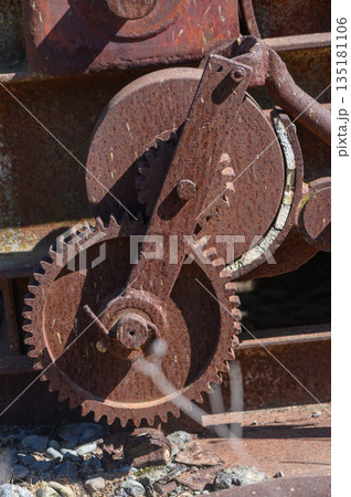 Rusty gears intertwining in a forgotten industrial landscape under bright sunlight Rusty gears intertwining in a forgotten industrial landscape under bright sunlight 135181106