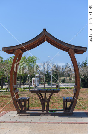 Relaxing wooden pavilion invites visitors to unwind in a serene park during a sunny day 135181149