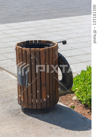 Creative trash bin design combines wood and tire for an artistic urban element in a bustling cityscape Creative trash bin design combines wood and tire for an artistic urban element in a bustling cityscape 135181300