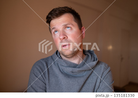 Skeptical male person reacting to a lie or stupid question, looking bored and fed up. 135181330