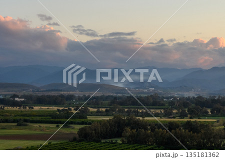Breathtaking sunset view over rolling hills and vibrant fields in a rural landscape during golden hour Breathtaking sunset view over rolling hills and vibrant fields in a rural landscape during golden hour 135181362