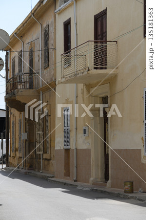 Charming architectural details adorn vintage buildings in a quiet backstreet of a historic town on a sunny afternoon Charming architectural details adorn vintage buildings in a quiet backstreet of a historic town on a sunny afternoon 135181363