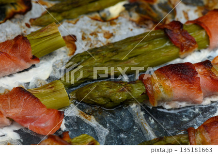 Savory asparagus wrapped in crispy bacon enhances gourmet dining experience at sunset gathering Savory asparagus wrapped in crispy bacon enhances gourmet dining experience at sunset gathering 135181663