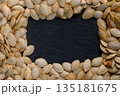 Creative arrangement of pumpkin seeds on a dark slate background captures the essence of autumn harv 135181675