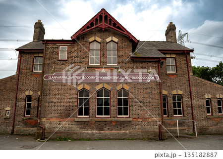 Name Plate On Trainstation Building Of Villag Llanfairpwllgwyngyllgogerychwyrndrobwllllantysiliogogogoch in Wales, UK 135182887