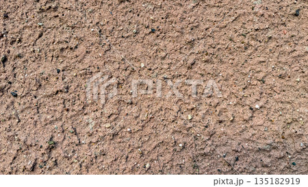 Close-up of a rough textured wall with pinkish sand and gravel plaster. Close-up of a rough textured wall with pinkish sand and gravel plaster. 135182919
